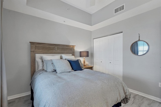 bedroom with light hardwood / wood-style flooring, a closet, and ceiling fan