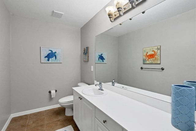 bathroom with toilet, vanity, and tile patterned floors