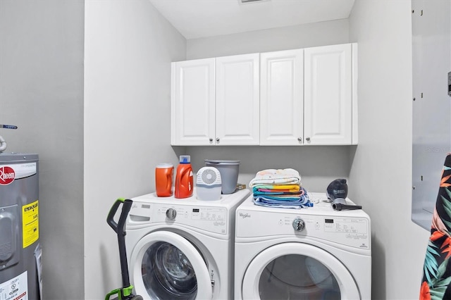 washroom featuring washer and dryer, cabinets, and electric water heater