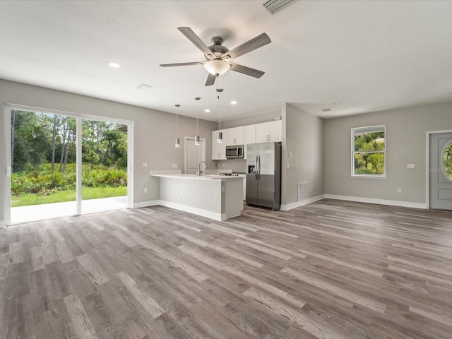 unfurnished living room featuring ceiling fan and light hardwood / wood-style floors