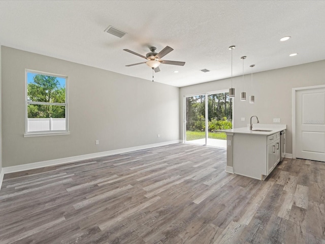 interior space featuring ceiling fan, a textured ceiling, sink, and light wood-type flooring