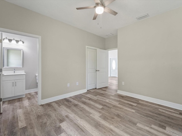 unfurnished bedroom with light hardwood / wood-style floors, ceiling fan, and connected bathroom