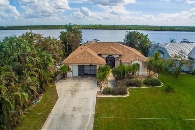 view of front facade with a garage, a water view, and a front yard