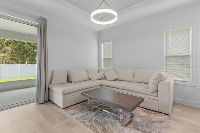 living room with a healthy amount of sunlight, light hardwood / wood-style floors, and crown molding