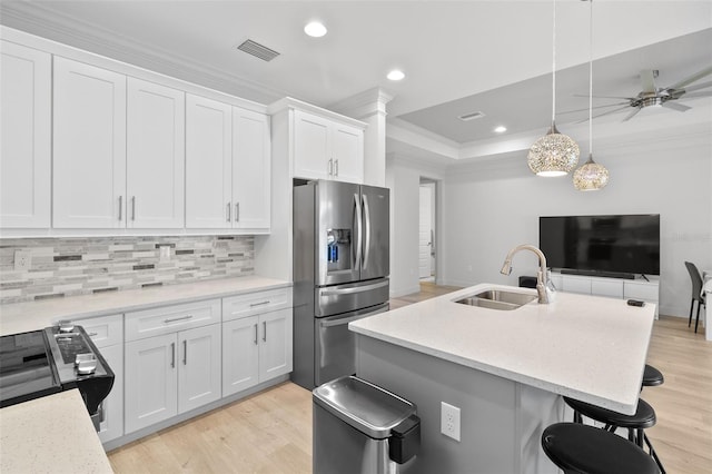 kitchen featuring white cabinetry, stainless steel appliances, sink, and light hardwood / wood-style flooring