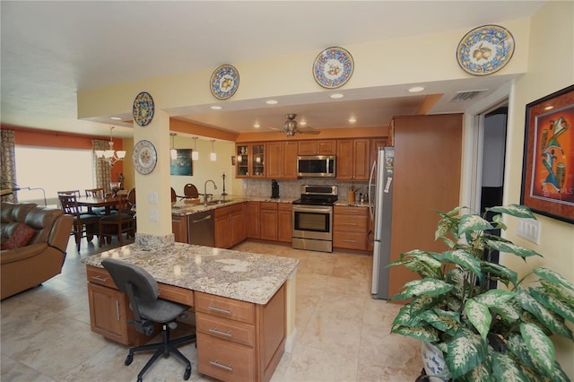 kitchen with kitchen peninsula, decorative backsplash, light stone counters, stainless steel appliances, and ceiling fan