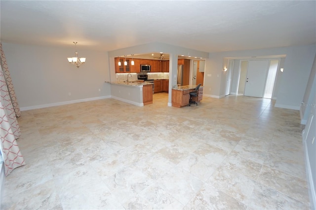 kitchen featuring kitchen peninsula, appliances with stainless steel finishes, sink, pendant lighting, and a chandelier