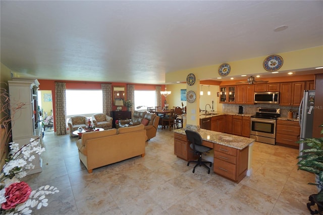 living room featuring sink and ceiling fan with notable chandelier