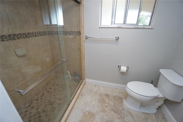 bathroom featuring toilet and a shower with door