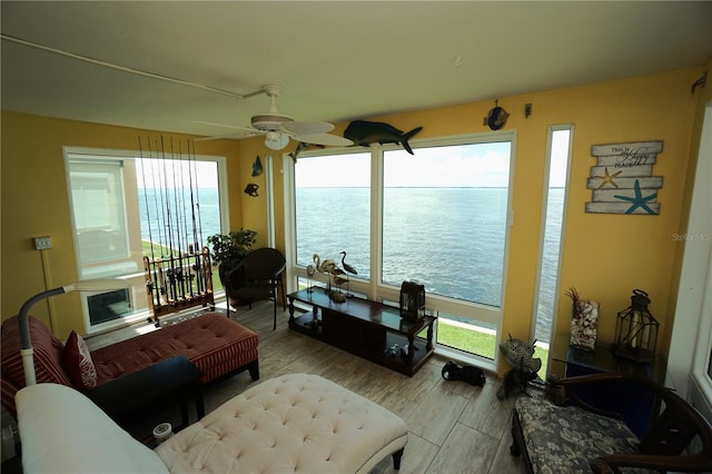 interior space featuring ceiling fan, a water view, and light wood-type flooring