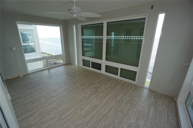 empty room featuring a water view and ceiling fan