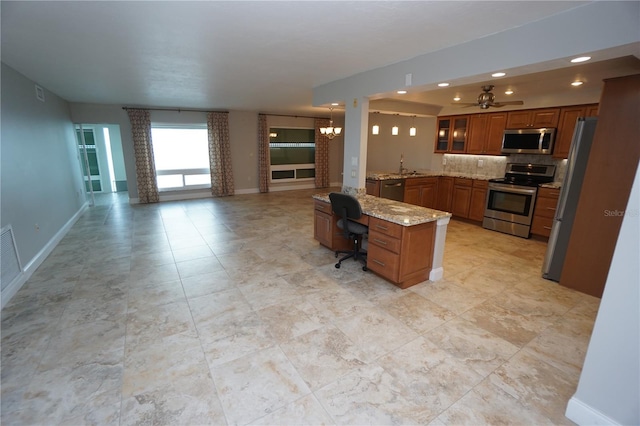 kitchen with light stone countertops, a kitchen breakfast bar, kitchen peninsula, stainless steel appliances, and ceiling fan