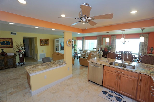 kitchen with hanging light fixtures, light stone countertops, sink, and stainless steel dishwasher