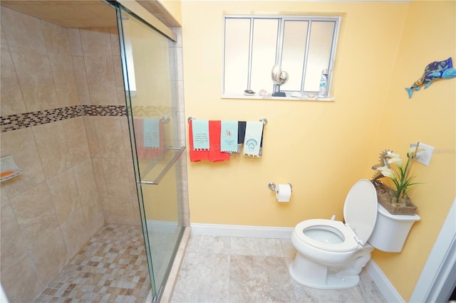 bathroom with toilet and a shower with door