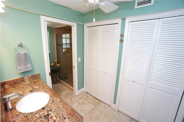 bathroom featuring tile patterned flooring, vanity, ceiling fan, and an enclosed shower