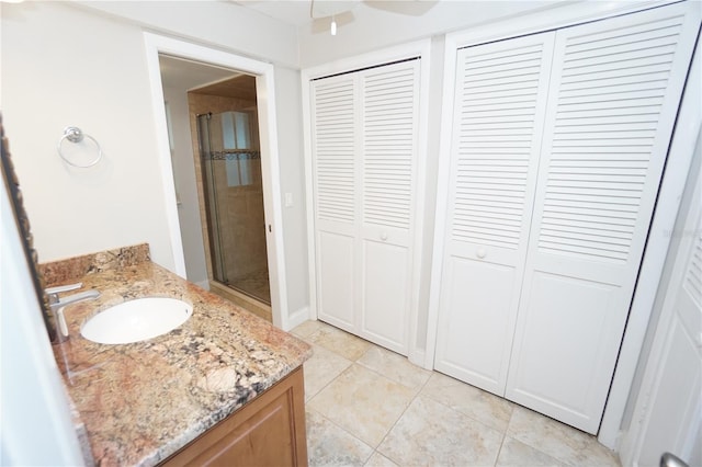 bathroom with ceiling fan, tile patterned flooring, vanity, and walk in shower