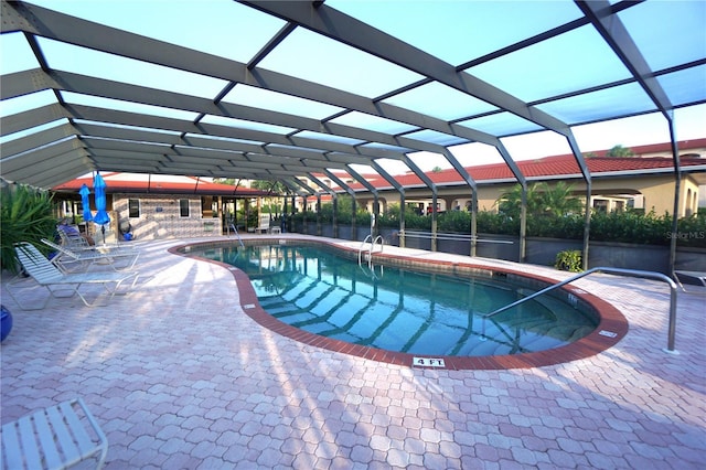 view of swimming pool with glass enclosure and a patio