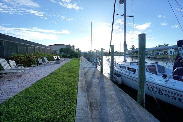 view of dock featuring a water view and a lawn