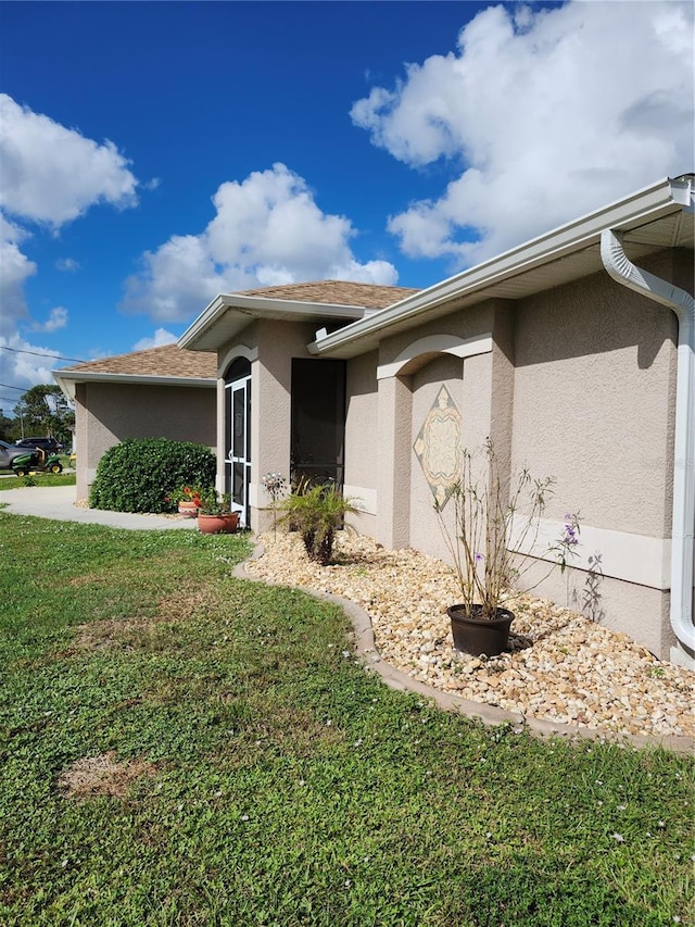 view of side of home with a lawn