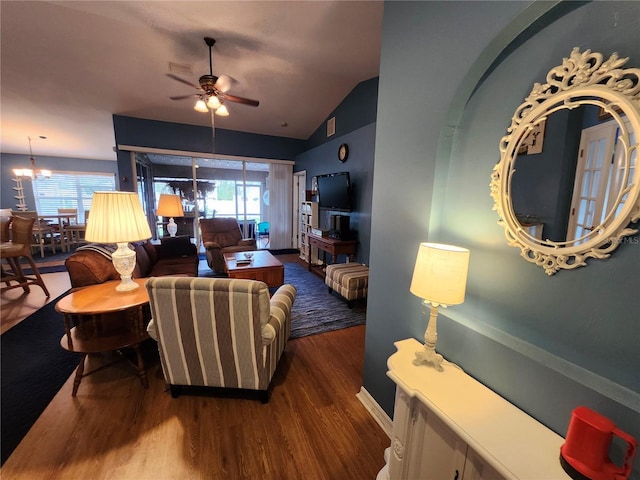 living room featuring hardwood / wood-style flooring, a wealth of natural light, lofted ceiling, and ceiling fan with notable chandelier