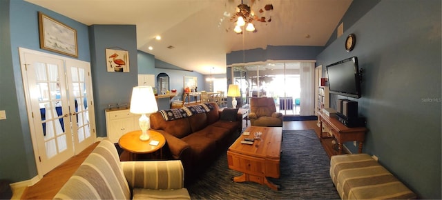 living room with hardwood / wood-style floors, an inviting chandelier, and high vaulted ceiling