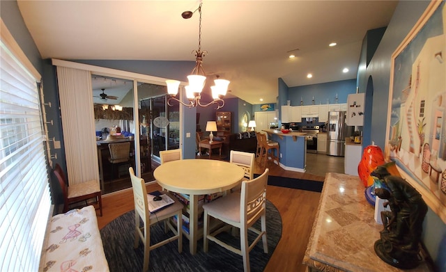 dining room with lofted ceiling, dark hardwood / wood-style floors, and ceiling fan with notable chandelier