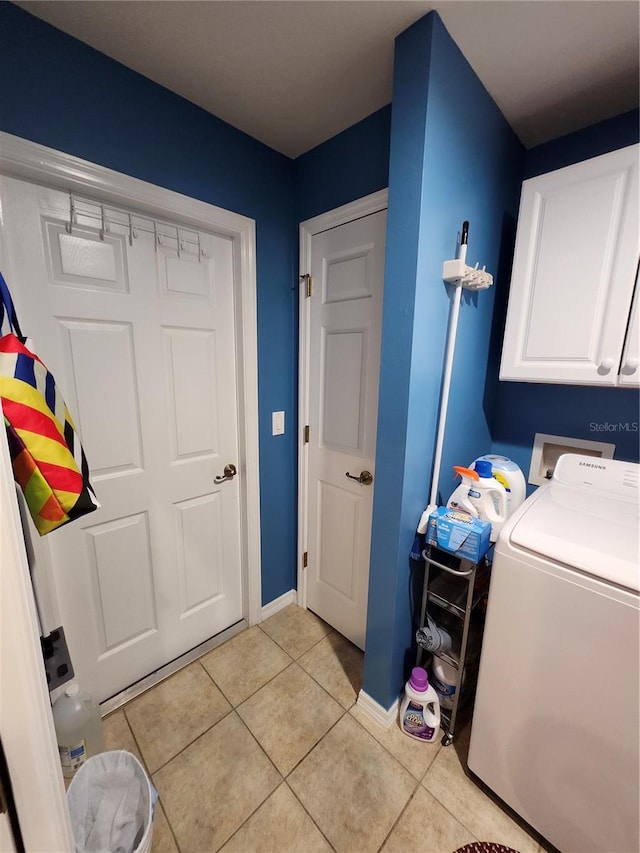 washroom with washer / clothes dryer, cabinets, and light tile patterned flooring