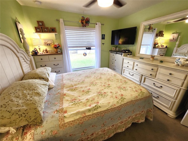 bedroom with ceiling fan, multiple windows, and dark colored carpet