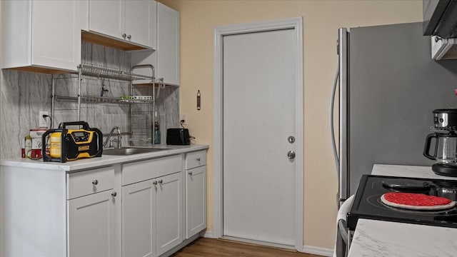 kitchen with white range with electric cooktop, dark hardwood / wood-style flooring, white cabinetry, and sink