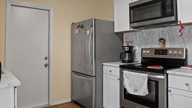 kitchen featuring white cabinets, appliances with stainless steel finishes, and tasteful backsplash