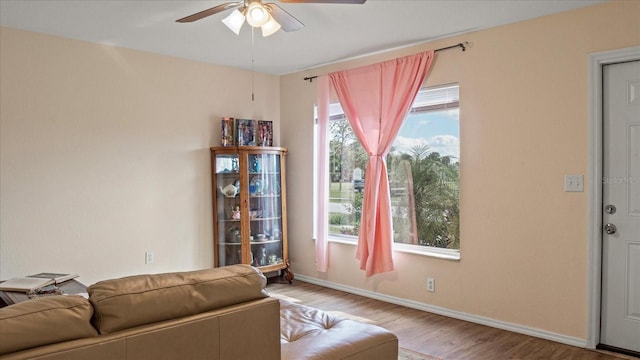 living room featuring plenty of natural light, ceiling fan, and light wood-type flooring