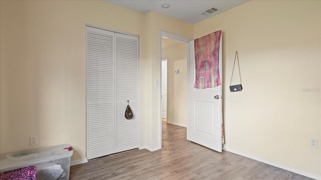 unfurnished bedroom featuring light hardwood / wood-style flooring and a closet