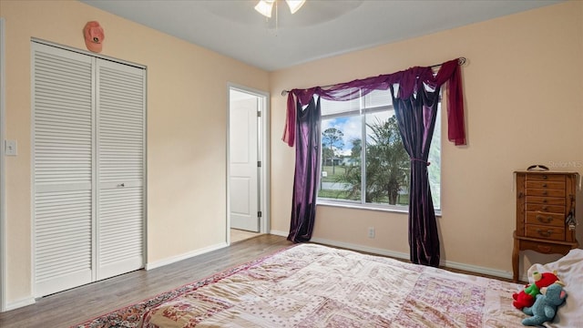 bedroom with hardwood / wood-style flooring, ceiling fan, and a closet