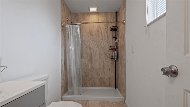 bathroom featuring vanity, toilet, and curtained shower