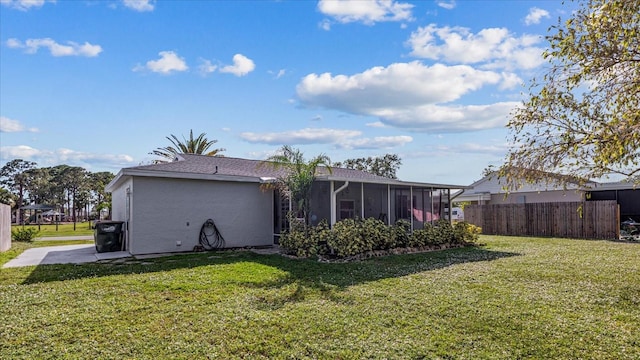 back of property featuring a yard and a sunroom