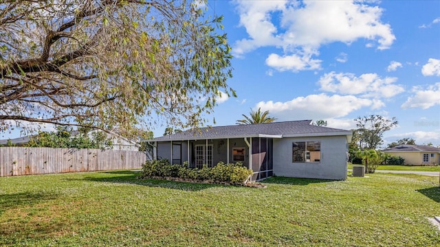 view of front of property featuring a sunroom, cooling unit, and a front lawn