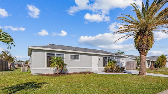 ranch-style home featuring cooling unit and a front yard