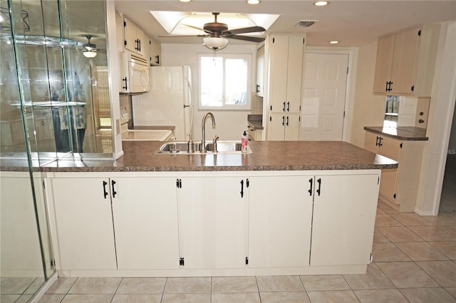 kitchen featuring white appliances, white cabinetry, sink, and kitchen peninsula