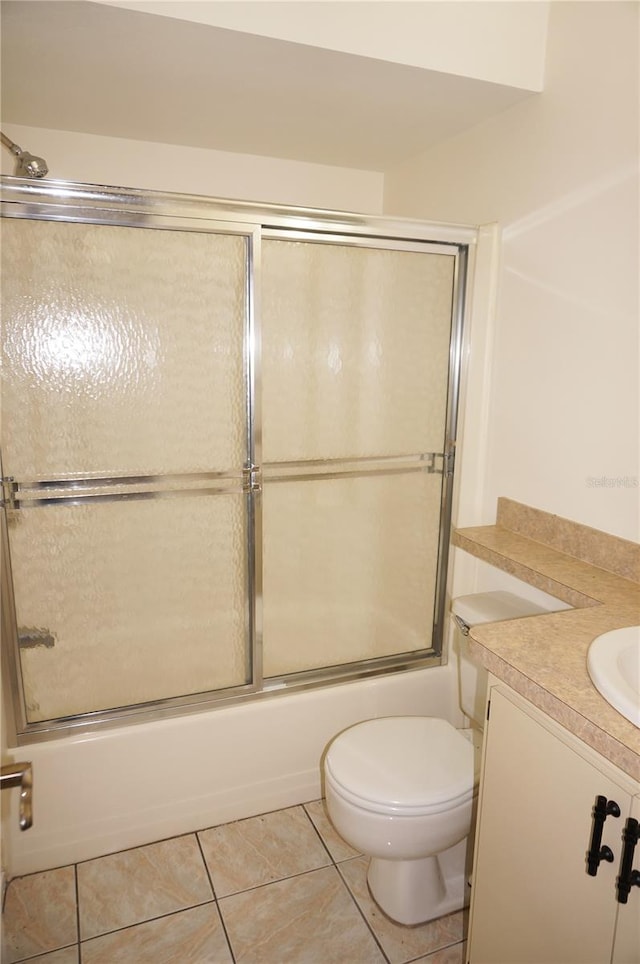 full bathroom featuring vanity, enclosed tub / shower combo, tile patterned floors, and toilet