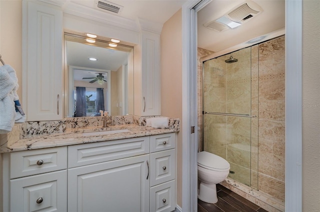 bathroom with ceiling fan, wood-type flooring, toilet, vanity, and a shower with shower door