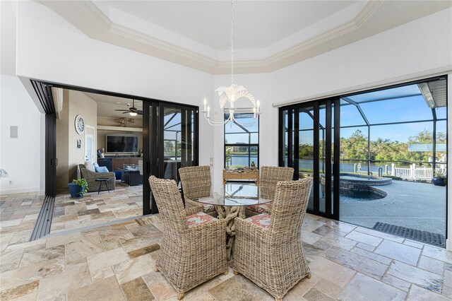 dining space with a raised ceiling, ceiling fan with notable chandelier, and ornamental molding