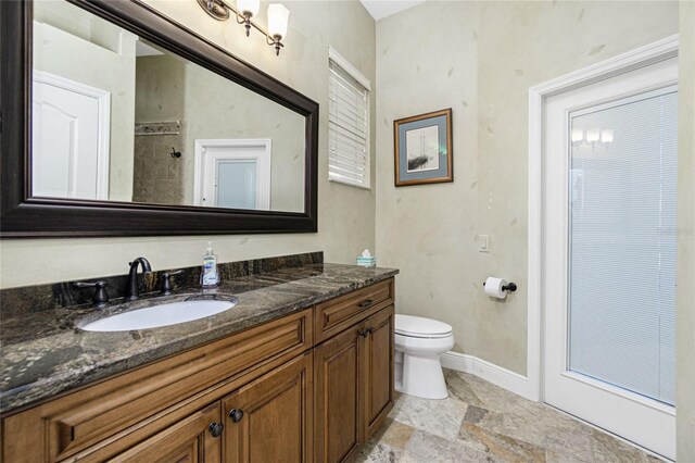 bathroom featuring vanity, toilet, and walk in shower