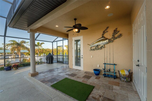 view of patio with glass enclosure and ceiling fan