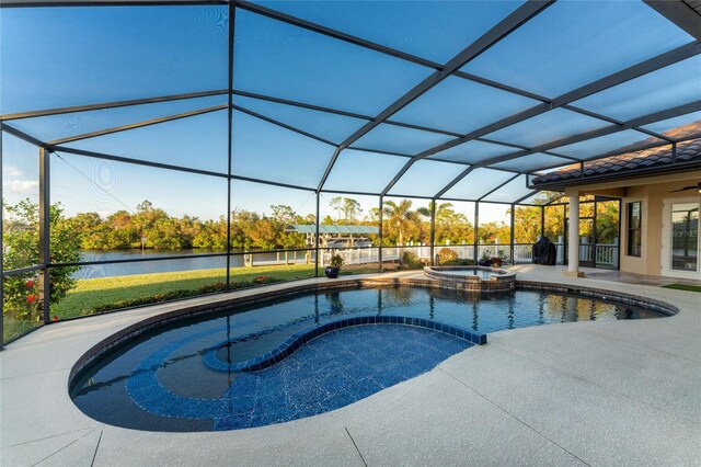 view of pool featuring glass enclosure, a patio area, a water view, and an in ground hot tub