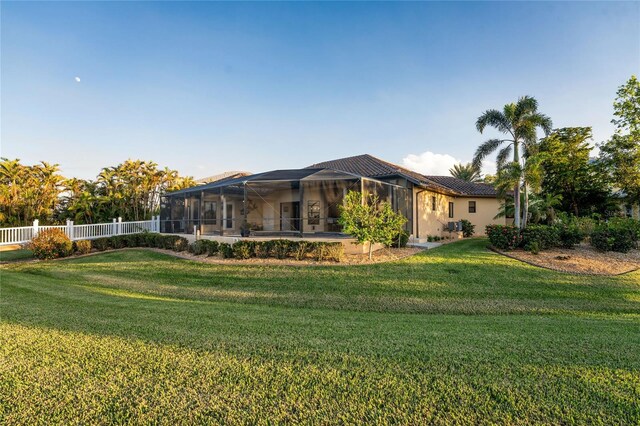 back of property with a yard and a lanai