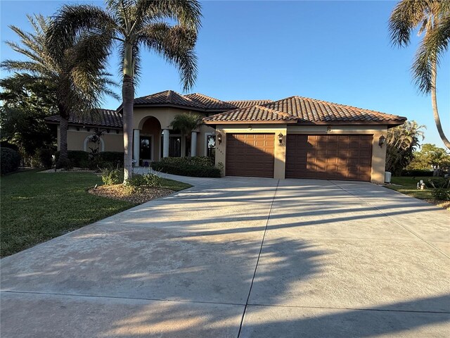 mediterranean / spanish-style house with a front lawn and a garage