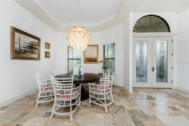 dining room featuring french doors, a tray ceiling, an inviting chandelier, and crown molding