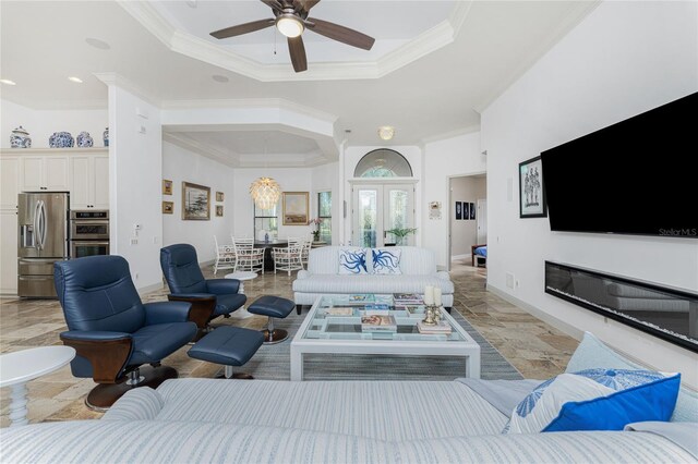 living room featuring a raised ceiling, crown molding, french doors, and ceiling fan