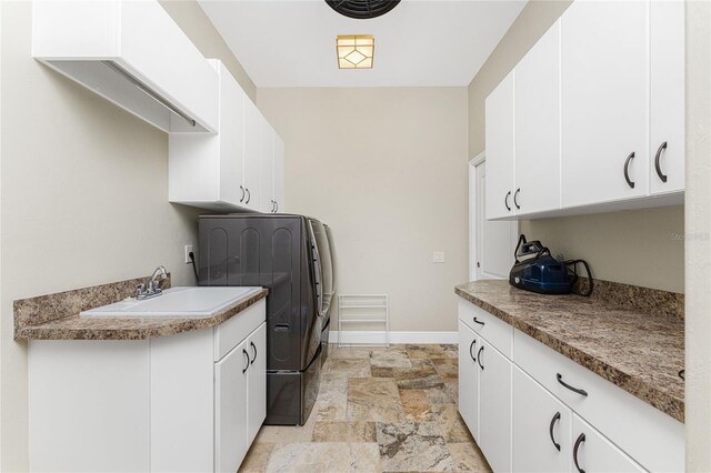 washroom featuring cabinets, sink, and washer / dryer