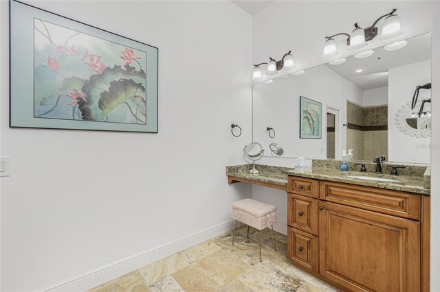 bathroom featuring tiled shower and vanity